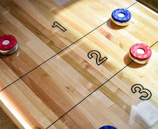 Shuffleboard table with metal pucks